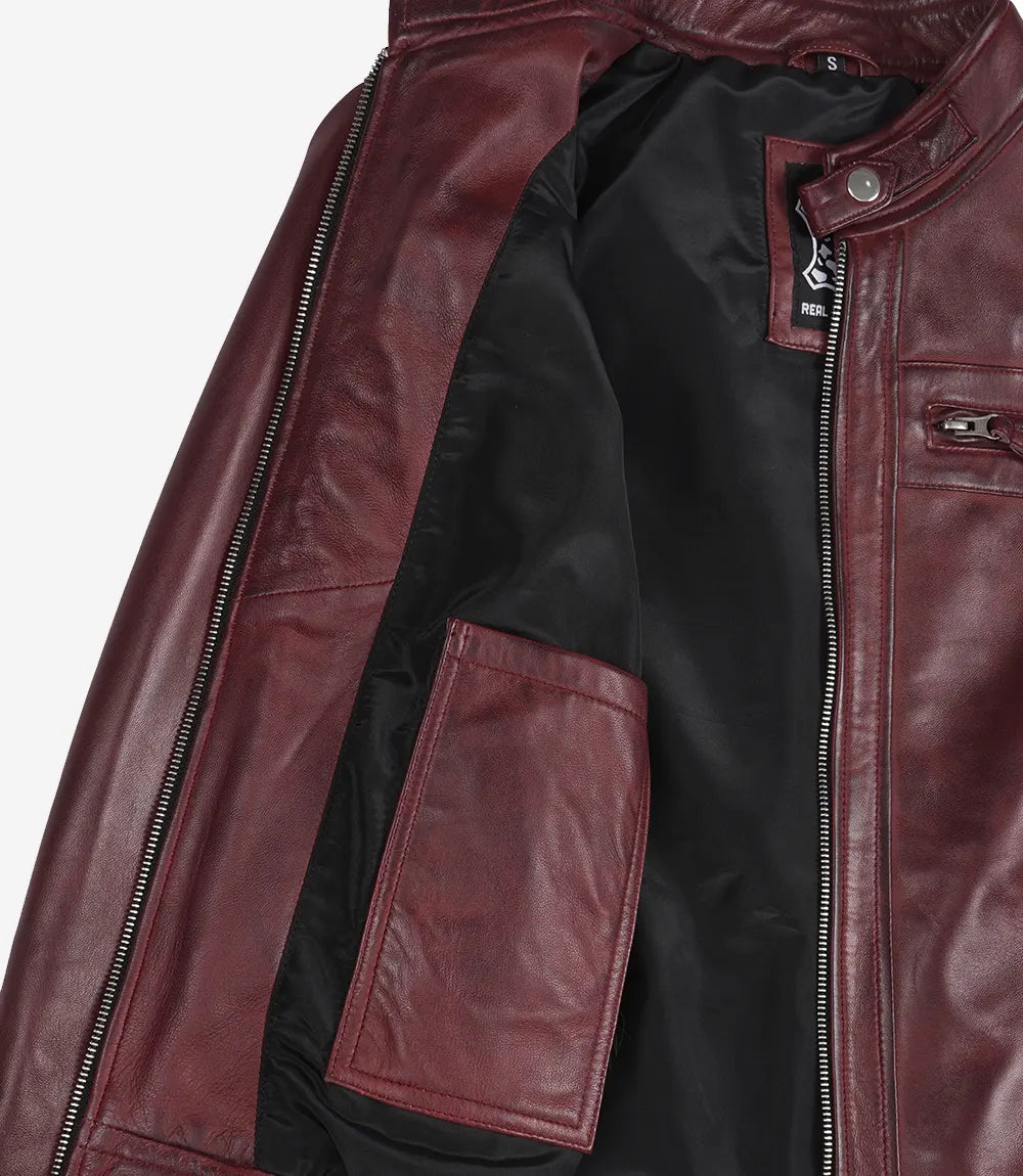 Close-up of a maroon leather jacket with a zipper on a white background